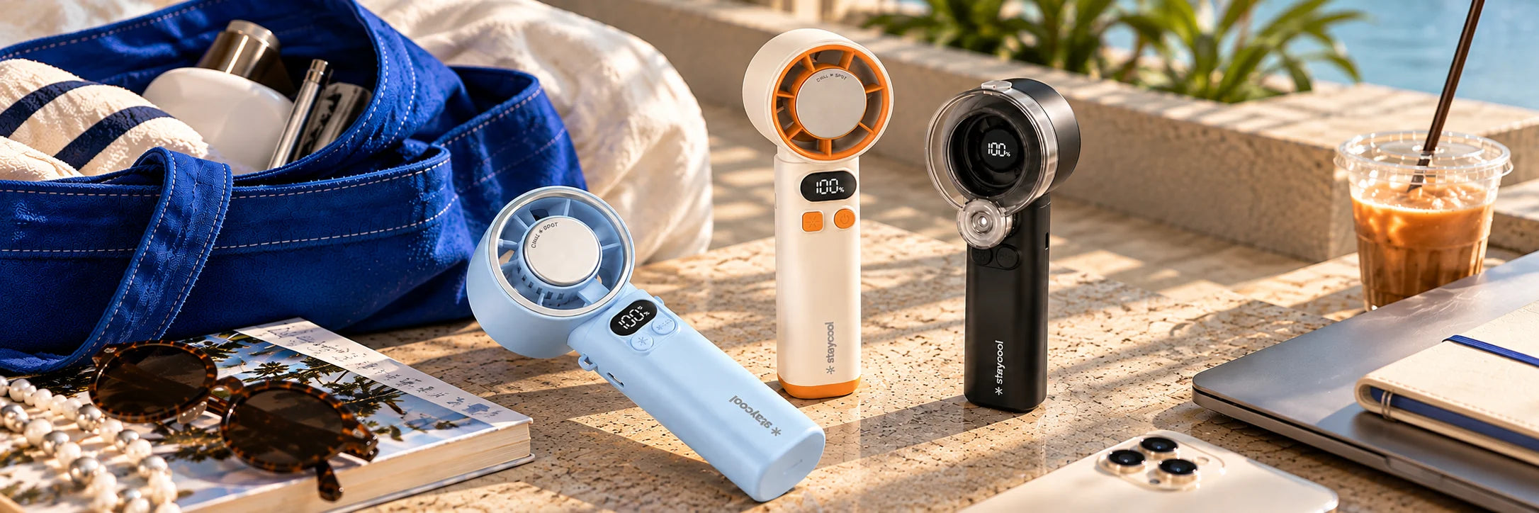 staycool turbo+, turbo and mist handheld fans on a sunlit poolside table